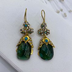 This fancy princess emerald statement ottoman drop earrings are inspired from sultan earrings in Topkapi museum. The similiar version can be seen in Topkapı İstanbul. Beautiful embellishments with blue turquoise and zircon are used on the top and joined tear drop emerald gemstone. The flower design decorated with zircon and turquoise below the kidney ear wire continues to tear drop shape emerald gemstone. It is a unique piece. Brass is plated with 24K gold micron which doesn't make color fading for years.  Handmade earrings Materials: 24K Gold plated brass, Gemstone: Emerald, zircon and turquoise Location: Earlobe Closure: Kidney ear wires Style: Tear drop Length: 5,5 cm / 2,16 inches Weight:15 g / 0,52 oz Traditional Green Jeweled Earrings, Traditional Green Earrings With Jewels, Statement Ottoman, Green Stone Earrings, Earrings Fancy, Tear Drop Earrings, Green Jewelry, Earrings Green, Green Earrings