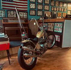 a motorcycle is parked in a room with many pictures on the wall and wooden floors