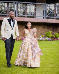 a man and woman in formal wear holding hands