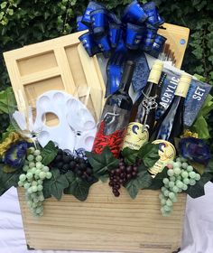 a wooden box filled with wine bottles and other assorted items next to greenery