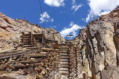 some stairs made out of wood and rocks under a blue sky with wispy clouds