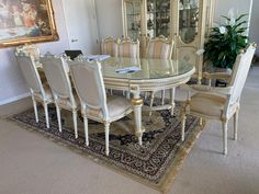 a dining room table with chairs and a rug on the floor