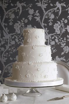 a wedding cake sitting on top of a table next to silverware and napkins