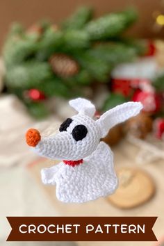 a crocheted white dog ornament hanging from a christmas tree with the words crochet pattern below it