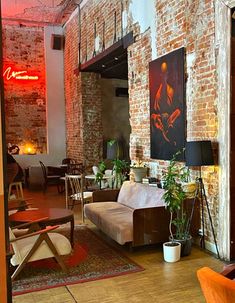 a living room filled with lots of furniture next to a red brick wall and ceiling