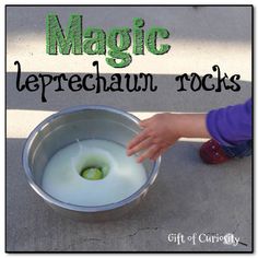 a child reaching into a metal container with liquid in it that says magic leprechaun rocks