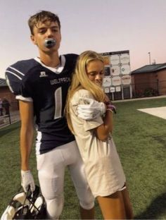 a man and woman standing on top of a football field