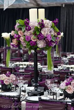 the centerpieces are decorated with purple flowers and candles