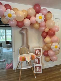 the balloon arch is decorated with flowers and balloons