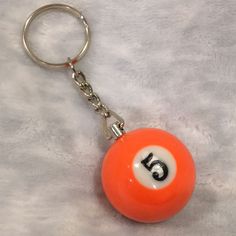 an orange keychain with a white and black number six billiard ball on it