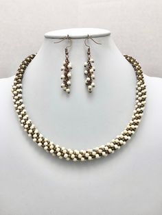 a necklace and earring set with pearls on a white mannequin headdress