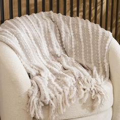 a white chair with a blanket on it