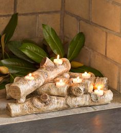 a group of candles sitting on top of a piece of wood