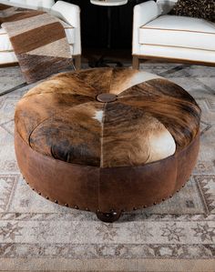 a cow hide ottoman sits in the middle of a living room