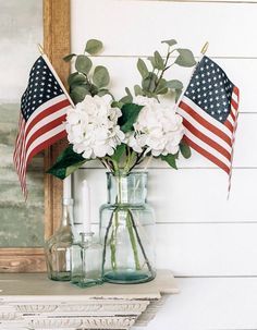 two vases with flowers and american flags in them