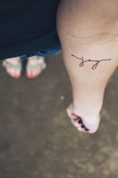 a woman's foot with the word joy written on it and her name in cursive writing