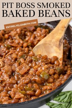 a skillet filled with baked beans and wooden spoon