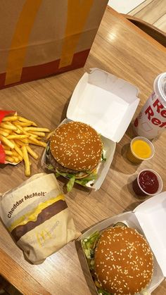 two hamburgers and fries on a table with ketchup, mustard, and french fries