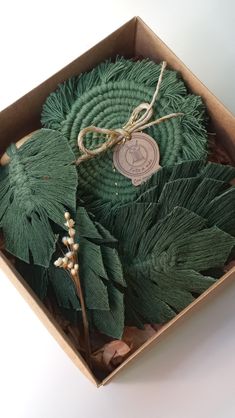 a box filled with green leaves on top of a table