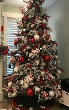 a christmas tree decorated with red, white and silver ornaments