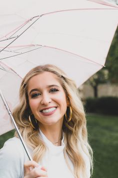 a smiling woman holding an umbrella in her hand