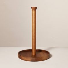 a wooden stand with a round base holding a wood object on it's side