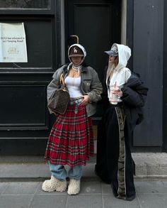 two people dressed in costumes standing next to each other on the side of a building