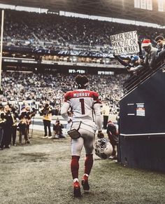 a football player is walking off the field with his team's name on it