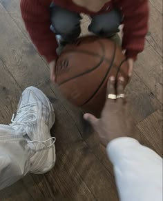 two people are playing with a basketball on the floor