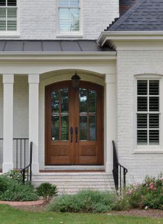 an image of a house with french doors on the front door and side porchs