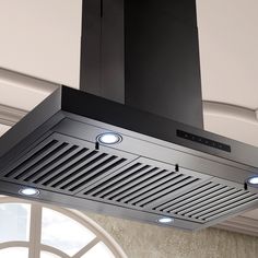 a black stove top oven mounted to the side of a wall with two lights on it