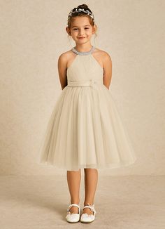 Honey is the perfect knee length dress for your sweet little girl. Cut from tulle, she features a pearl halter neckline, a pleated bodice, a scoop back, a ruched A-line skirt, and a beautiful beaded flower over her satin belt. Champagne Flower Girl Dresses, Honey Flower, Champagne Flower Girl, Flower Girl Dresses Champagne, Champagne Flowers, Satin Belt, Flower Girl Dresses Tulle, Pleated Bodice, Matte Satin