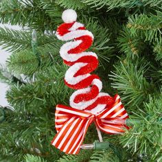 an ornament hanging from a christmas tree with red and white candy canes