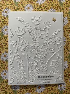 a white card with flowers on it that says thinking of you