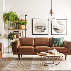 a living room with two couches, a coffee table and pictures on the wall