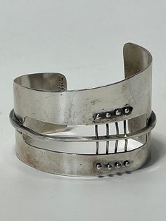 An Extraordinary cuff bracelet designed by Ed Wiener (1918-1991). This rare sculptural modernist piece is one of Wiener's first creations as a jeweler-artist in New York city, circa 1950's. This bracelet is composed by six elements with sinuous curved and free forms shapes which in turn recreates a sculpture with constructivism patterns. It was individually constructed and crafted in solid .925/.999 of polished and patinated sterling silver.  Bio: Ed Wiener (1918-1991), began his career in the artist's circles of the post-Bauhaus. Was very active at Provincetown and the Greenwich village in New York. Work immediately in the early days of the abstract expressionist movement of the post-war period, late 1940's. His most famous customers was the sculptor Louise Nevelson and Martha Graham, the Modernist Polished Cuff Bracelet, Modernist Polished Cuff Bangle Bracelet, Modernist Sterling Silver Bangle, Modernist Cuff Bracelet With Polished Finish, Modernist Bangle Cuff Bracelet For Formal Occasions, Sterling Silver Modernist Bangle, Contemporary Sterling Silver Bangle Bracelet, Contemporary Adjustable Sterling Silver Bracelet, Adjustable Modernist Bangle For Formal Occasions