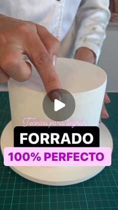 a person is making a cake with fondant on the top and one hand pointing at it