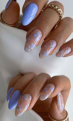 a woman's hands with blue and white manies on their nails, one is holding