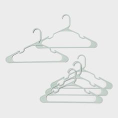 three white clothes hangers on a gray background