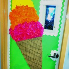 an ice cream cone decorated with pink and orange flowers in front of a green door