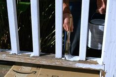 a person holding a brush near a cardboard box