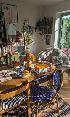 a living room filled with lots of furniture and books on top of a wooden table