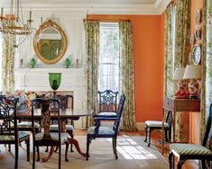 the dining room is decorated in orange and green with an ornate chandelier hanging from the ceiling