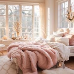 a bed with pink blankets and pillows in front of two large windows, surrounded by candles