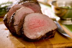 sliced meat sitting on top of a wooden cutting board