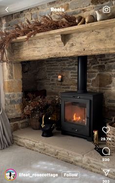 a fire place in the middle of a room with stone walls and flooring on both sides