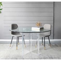 a glass dining table with two chairs and a vase on the side next to it