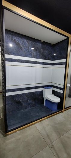 a white toilet sitting inside of a bathroom next to a blue and gold wall mounted mirror