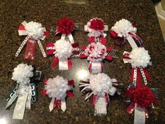 red, white and silver hair clips with flowers on them sitting on a counter top