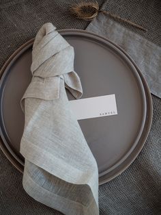 a plate with a napkin on it and a place card sitting on top of it